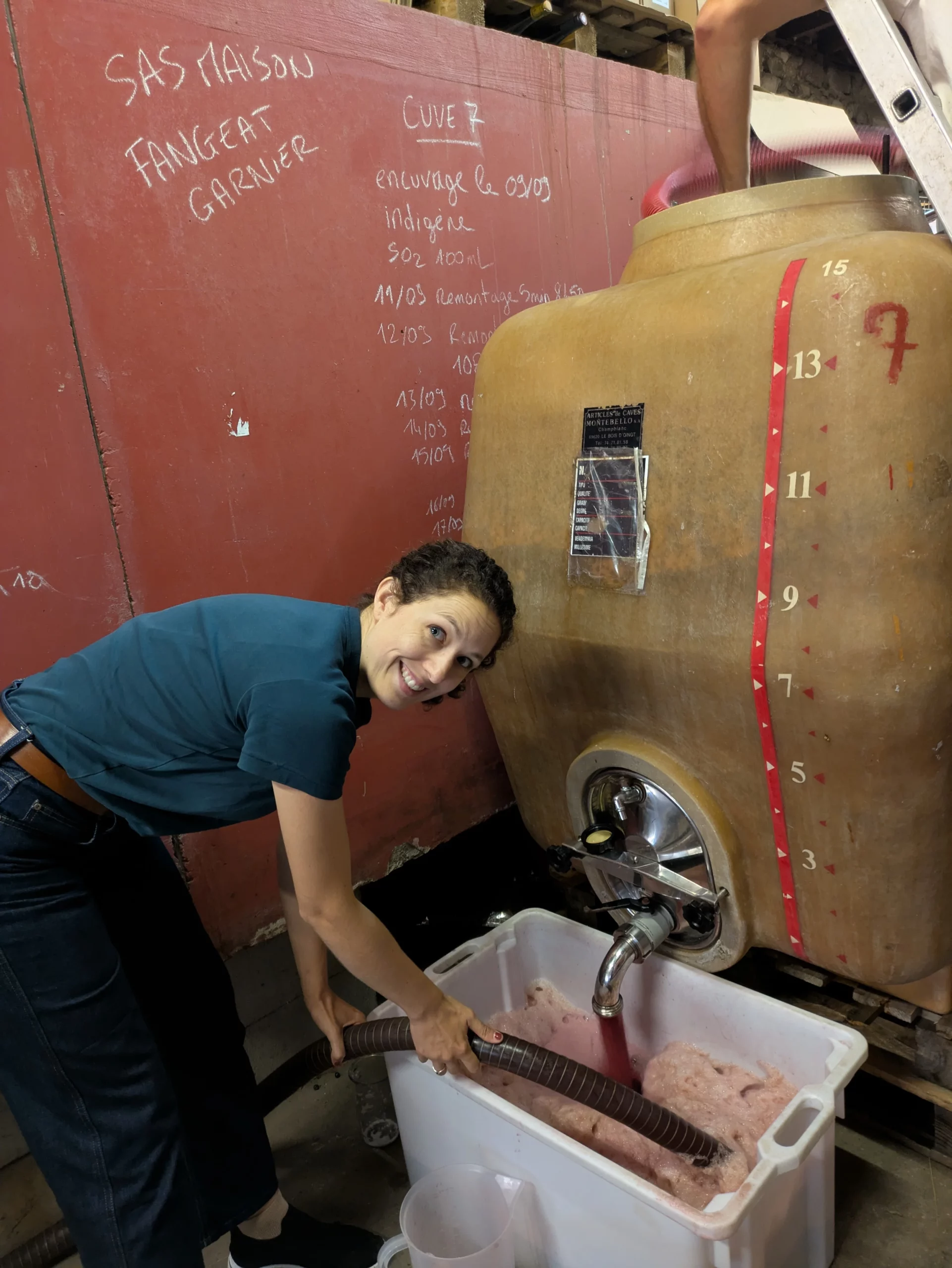 Inès Delmotte, œnologue Les Épicurieuses, effectuant un remontage lors de la vinification dans un chai en Beaujolais.