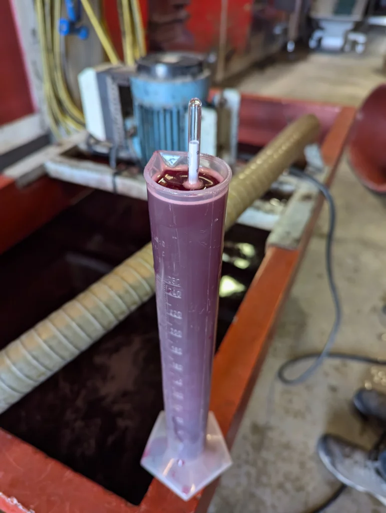 Mesure de la densité du moût de raisin avec un mustimètre dans une éprouvette graduée lors de la fermentation en Beaujolais.